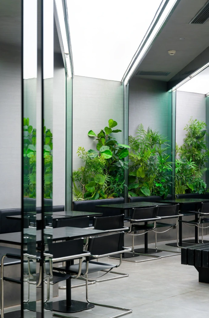 Modern cafe interior with black tables and plants